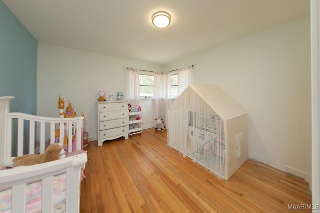 bedroom featuring a crib and wood finished floors