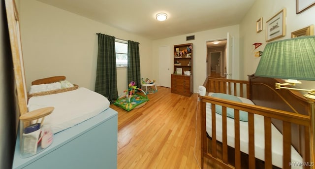 bedroom with visible vents and light wood-type flooring