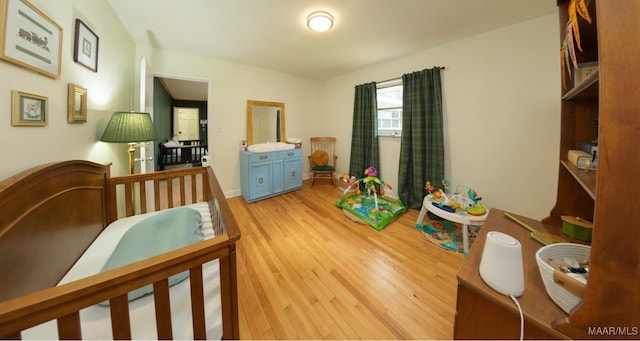 bedroom with light wood-style flooring and baseboards