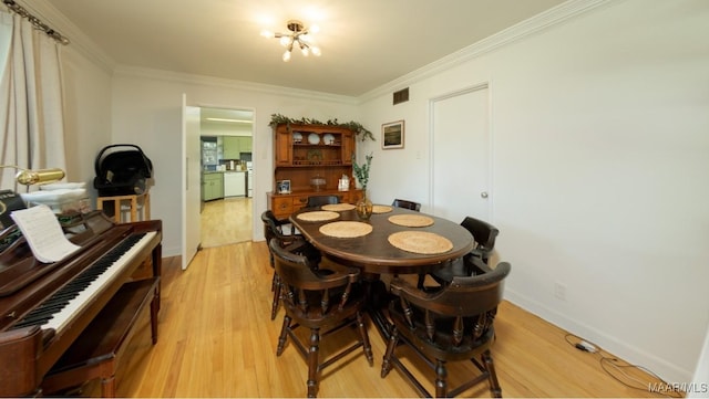 dining area featuring baseboards, crown molding, and light wood finished floors