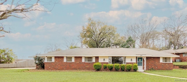 single story home with a front yard, fence, and brick siding