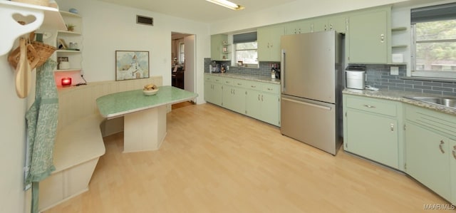 kitchen with visible vents, light wood finished floors, open shelves, freestanding refrigerator, and light countertops