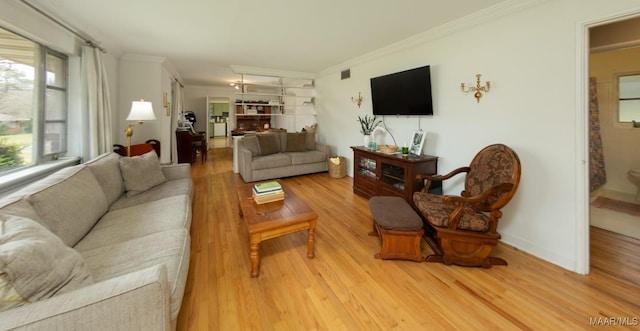 living room with light wood finished floors, visible vents, crown molding, baseboards, and a fireplace