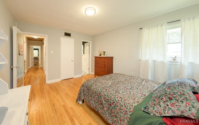 bedroom with visible vents, baseboards, and light wood-style flooring