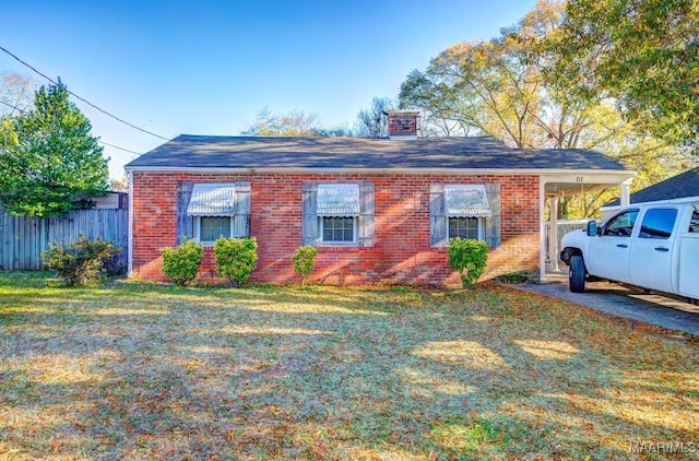 view of front of home featuring brick siding, a front lawn, and fence