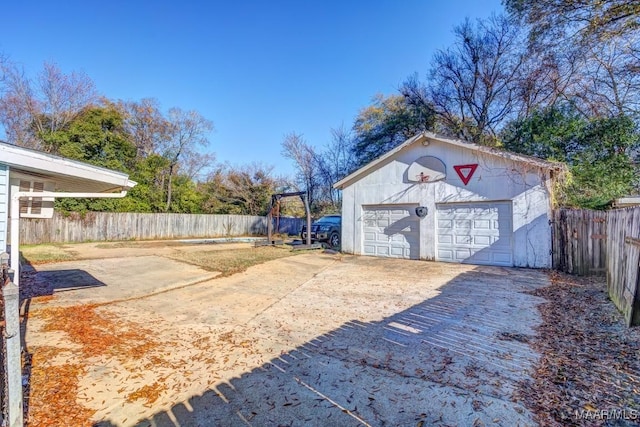 view of yard featuring an outbuilding, fence, and a garage
