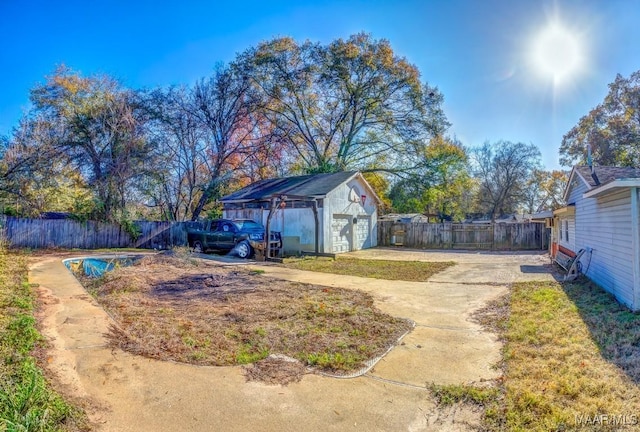 view of yard with a detached garage, an outdoor structure, and fence