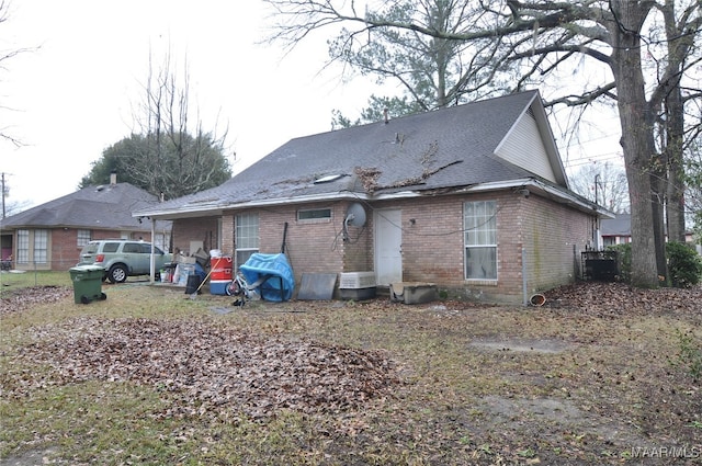 back of house featuring brick siding and central air condition unit