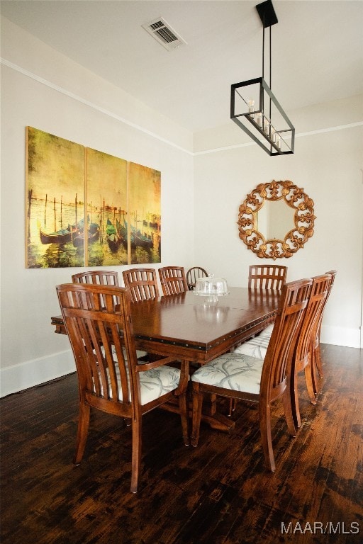 dining space with wood finished floors, visible vents, and baseboards