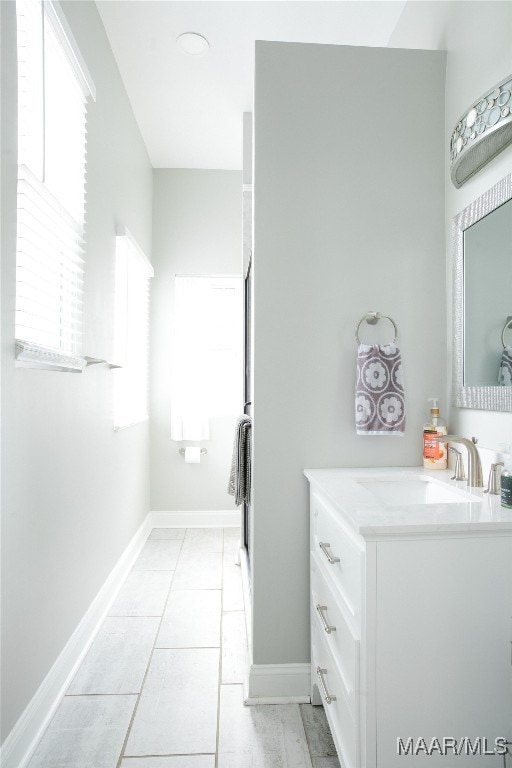 bathroom with vanity, tile patterned floors, and baseboards