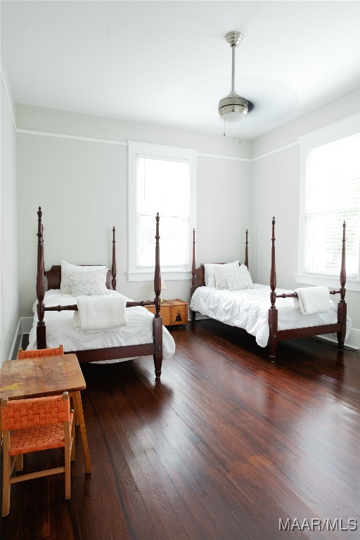 bedroom with multiple windows and wood finished floors