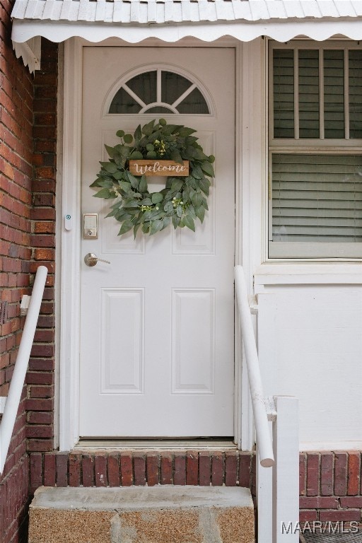 entrance to property featuring brick siding