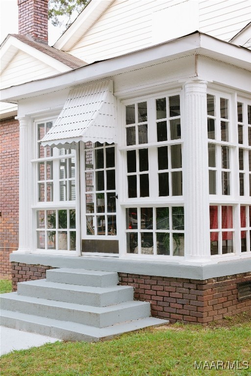 entrance to property with brick siding and a chimney