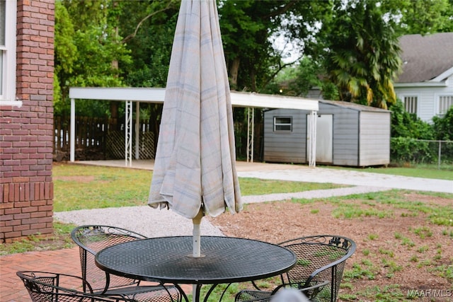 view of patio with an outdoor structure, a storage unit, and fence