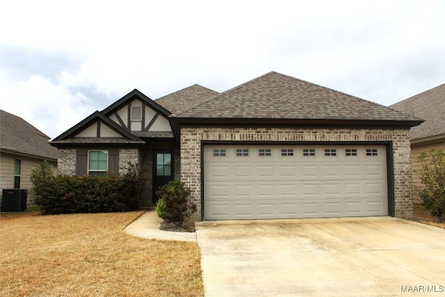 view of front of home featuring cooling unit, a garage, roof with shingles, and driveway