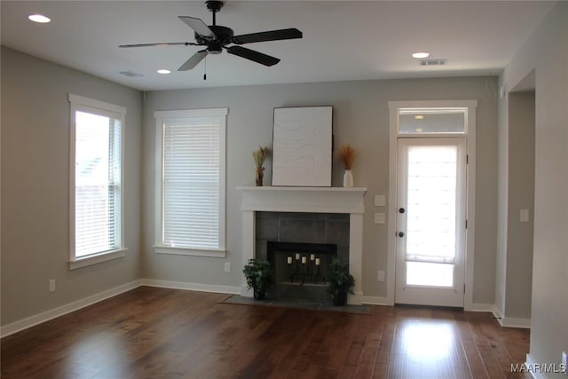 unfurnished living room featuring a fireplace, visible vents, wood finished floors, and baseboards