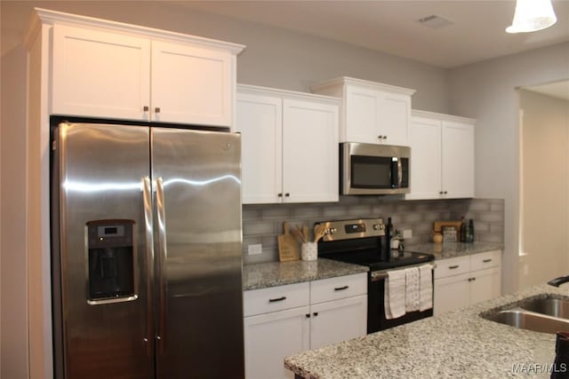 kitchen featuring a sink, backsplash, appliances with stainless steel finishes, and white cabinets