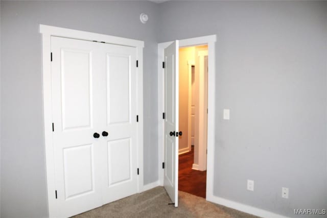 unfurnished bedroom with carpet flooring and a closet