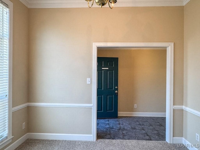 interior space featuring an inviting chandelier, crown molding, and baseboards