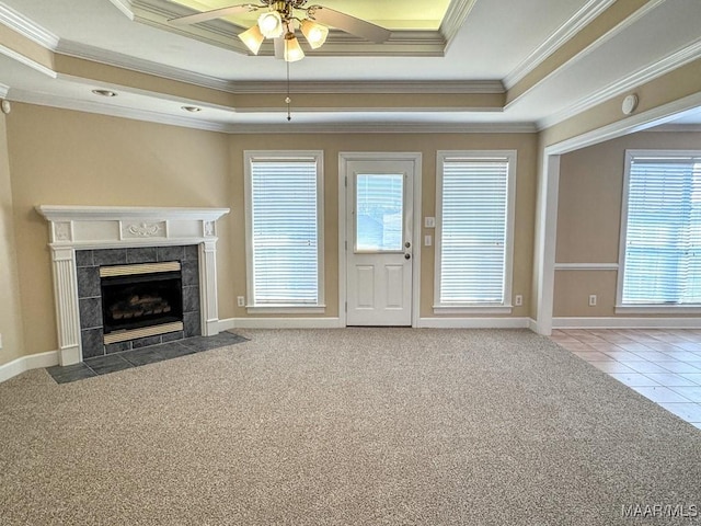 unfurnished living room featuring a tray ceiling, a ceiling fan, a fireplace, and carpet flooring