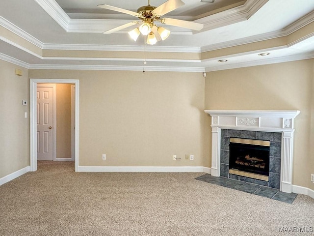 unfurnished living room featuring a raised ceiling, carpet floors, and a tile fireplace