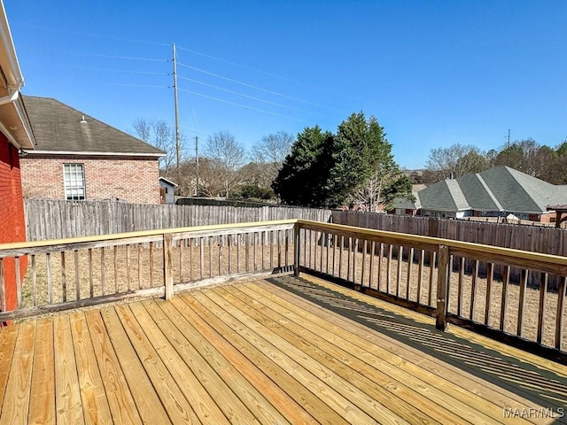 wooden terrace with a fenced backyard