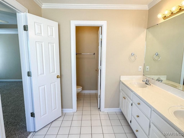 bathroom with double vanity, toilet, crown molding, and a sink