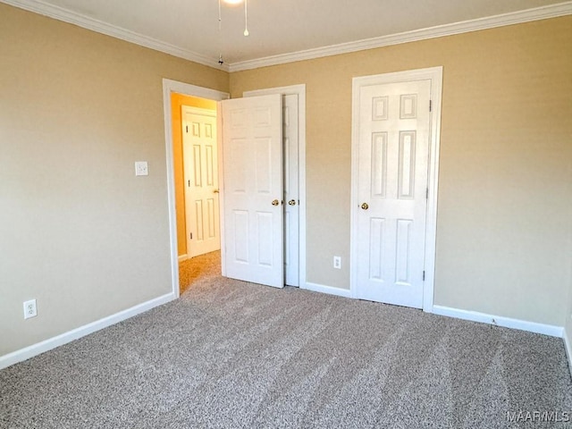 unfurnished bedroom with crown molding, carpet flooring, and baseboards