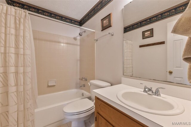 full bathroom with shower / bath combo with shower curtain, toilet, vanity, and a textured ceiling