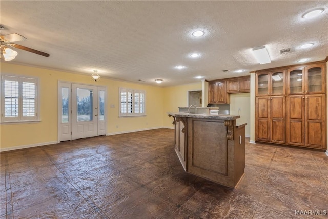 kitchen featuring plenty of natural light, brown cabinets, and baseboards