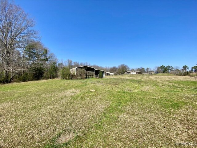 view of yard featuring a carport, an outbuilding, and a pole building