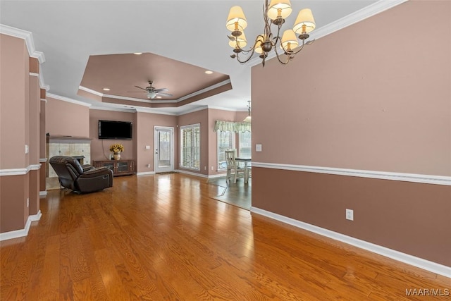 125 Greenfield Pl, Wetumpka, AL 36093 - unfurnished living room featuring wood finished floors, baseboards, a tray ceiling, ornamental molding, and ceiling fan with notable chandelier