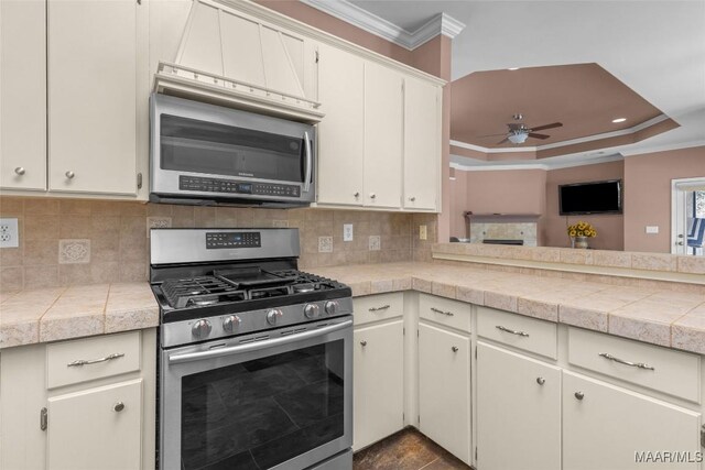 125 Greenfield Pl, Wetumpka, AL 36093 - kitchen with backsplash, ceiling fan, ornamental molding, appliances with stainless steel finishes, and a raised ceiling