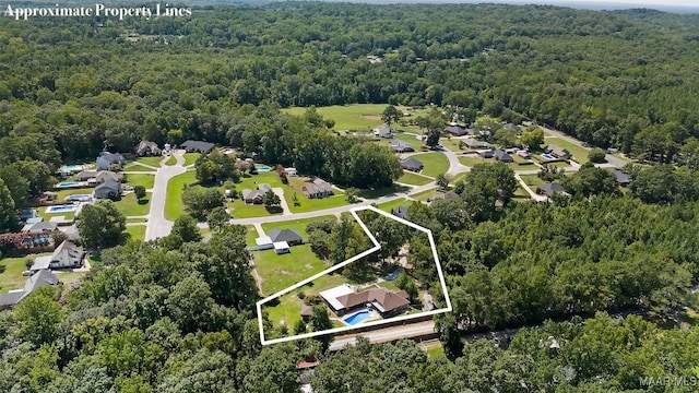 birds eye view of property featuring a view of trees