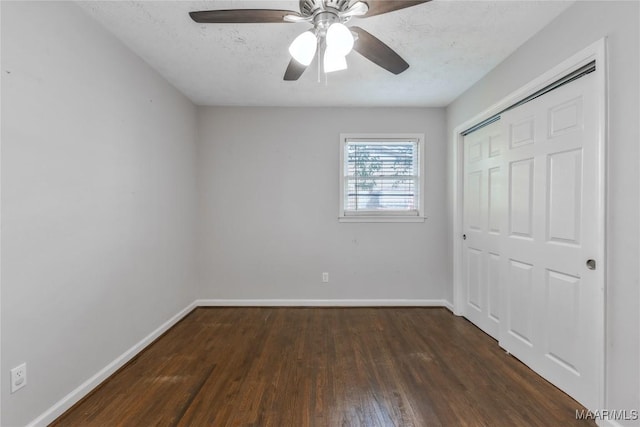 unfurnished bedroom with baseboards, wood finished floors, a closet, a textured ceiling, and a ceiling fan