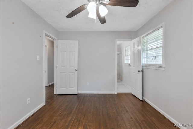 unfurnished bedroom with baseboards, wood finished floors, and a ceiling fan