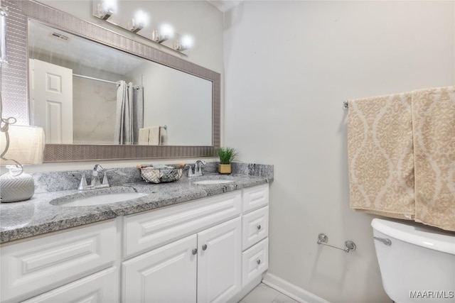 bathroom featuring a sink, toilet, a shower with shower curtain, and double vanity