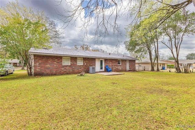 back of house with brick siding, fence, central air condition unit, a yard, and a patio area