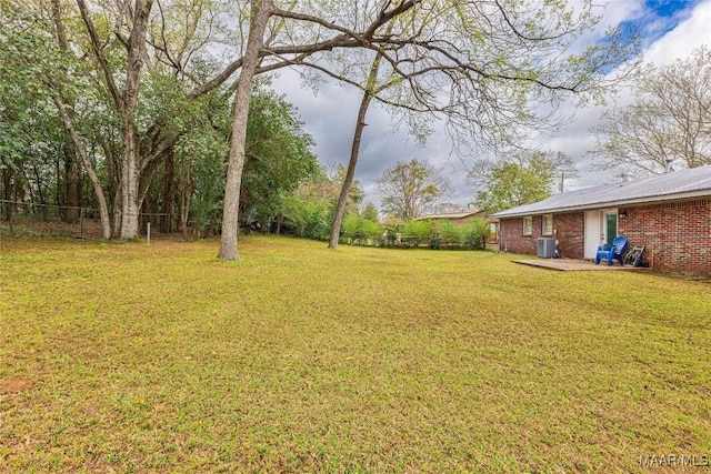 view of yard with central AC unit and fence