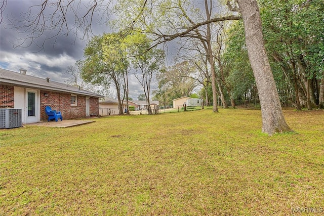 view of yard with a patio, central air condition unit, and fence