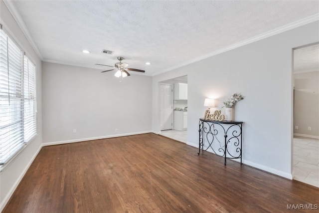 interior space with crown molding, plenty of natural light, visible vents, and ceiling fan