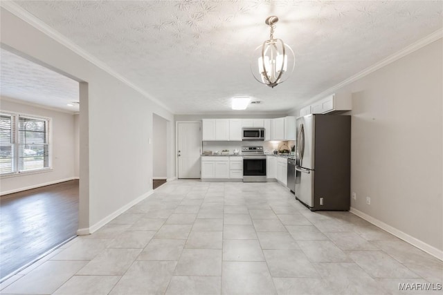 kitchen featuring a chandelier, light countertops, ornamental molding, appliances with stainless steel finishes, and white cabinets