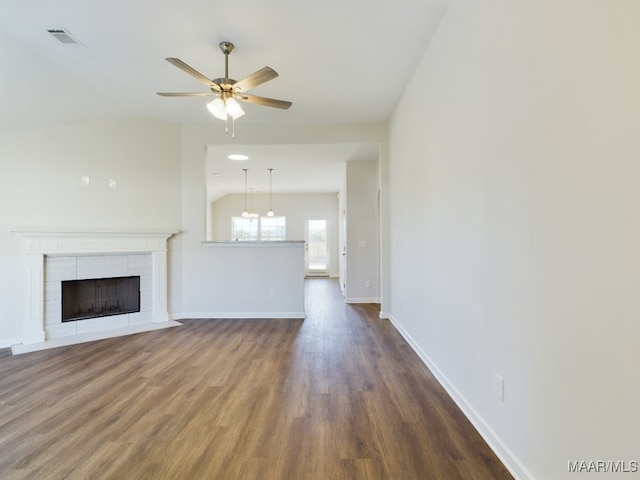 unfurnished living room with dark wood-type flooring, a fireplace, baseboards, ceiling fan, and vaulted ceiling