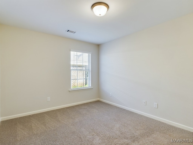 empty room with visible vents, baseboards, and carpet floors