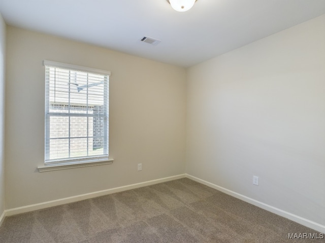 empty room with visible vents, carpet flooring, and baseboards