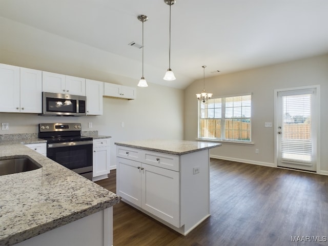 kitchen featuring light stone countertops, dark wood finished floors, stainless steel appliances, a notable chandelier, and white cabinetry