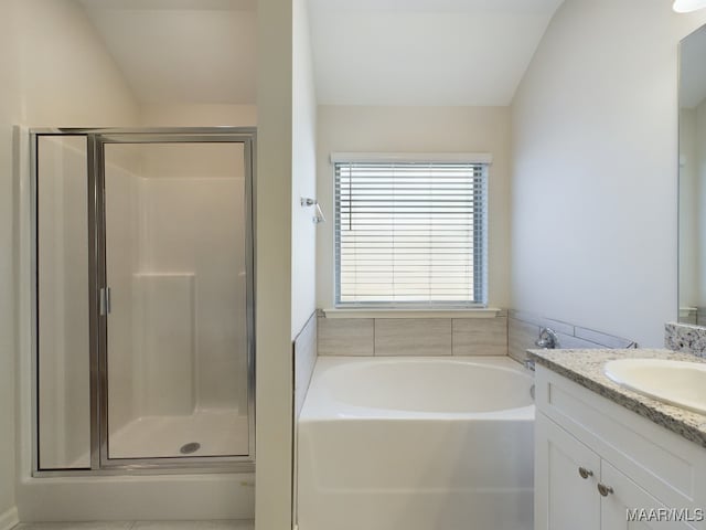 bathroom with a stall shower, vanity, and a bath