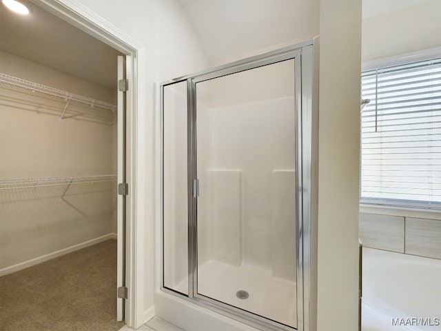 full bath with a garden tub, a spacious closet, and a shower stall