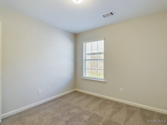 empty room featuring visible vents, baseboards, and carpet floors