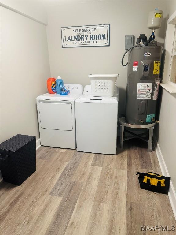 laundry area with electric water heater, baseboards, laundry area, light wood-style flooring, and washer and dryer